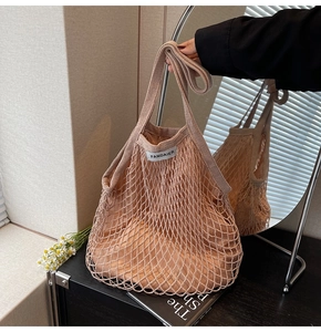 Detail van roze geweven mesh draagtas met bijpassende voering en een stoffen merklabel