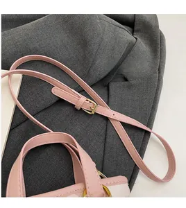 Dettaglio della borsa a secchiello rosa trapuntata con tracolla e fibbia dorata