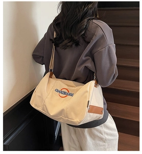 Détail du sac cabas en toile beige avec broderie et finitions en cuir marron