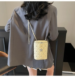 Détail du sac bandoulière matelassé crème avec emblème étoile et bandoulière en chaîne