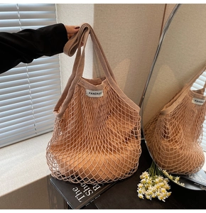 Detail van handgeweven holle mesh draagtas met beige stoffen voering en merklabel
