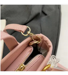 Dettaglio della borsa a secchiello in ecopelle rosa chiaro con finiture dorate e fodera