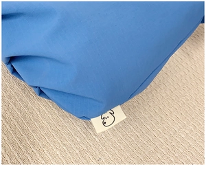 Nahaufnahme von blauem Ripstop-Gewebe mit kleinem Hundesymbol-Label an einer Umhängetasche