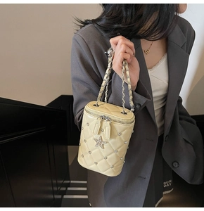 Sac seau matelassé avec étoiles en strass porté en bandoulière par un mannequin chic