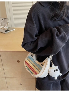 Chic multi-color woven crescent bag with cream leather trim and plush pendant for women
