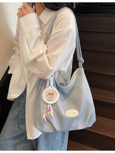 Sac hobo en jean bleu clair à motif jacquard avec charme capybara porté par un mannequin