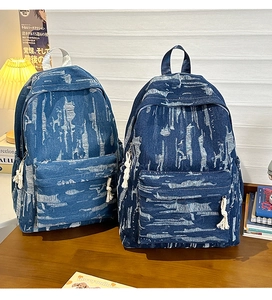 Detail of distressed denim backpacks in light and dark blue with vintage texture