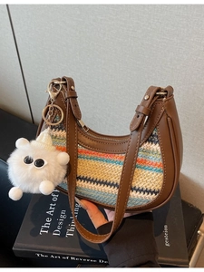 Striped woven straw hobo bag with brown leather trim and cute plush monster charm