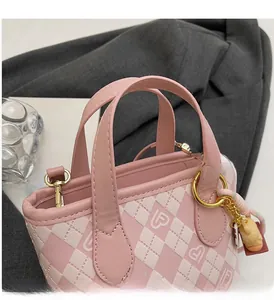 Dettaglio della borsa a secchiello in pelle PU a scacchi rosa e bianca con ciondolo a orsetto