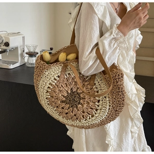 Detail of hollow paper rope woven beach bag with gradient circular pattern and leather strap