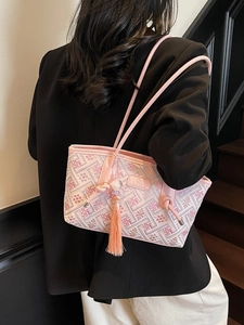 Minimalistische rosa Tragetasche mit Stickerei und Quastenanhänger an der Schulter
