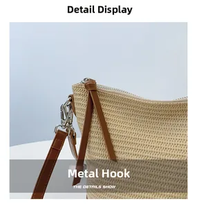 Detail view of silver metal hook and brown leather strap on beige woven shoulder bag