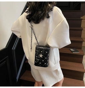 Détails du sac seau noir matelassé avec clous perle et ornement étoile brillante
