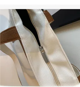Détail de la fermeture éclair en métal sur un sac en toile blanc cassé avec sangle