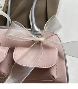 Detailed macro view of pink fabric bag with silver leather trim and organza bow detail