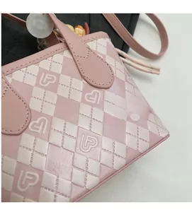 Dettaglio della borsa a secchiello trapuntata rosa e bianca con logo a cuore e trama