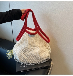 Detailweergave van de rood-witte gehaakte draagtas met binnentas en merklogo