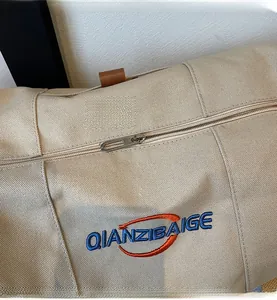 Gros plan sur la fermeture éclair lisse et la broderie bleue sur le sac cabas en toile