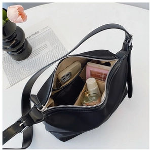 Detail view of the spacious interior compartment of a black hobo bag with daily essentials