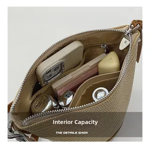 Detail showing inner capacity of straw woven shoulder bag with daily items inside