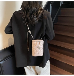 Détail du mini sac seau matelassé rose avec ornement étoile porté à l'épaule