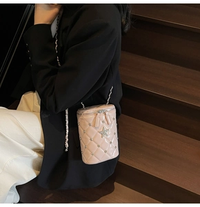 Détail du sac seau rose en cuir verni matelassé avec étoiles et bandoulière chaîne