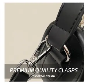 Detail of silver metal swivel hook and black leather shoulder strap with reinforced stitching