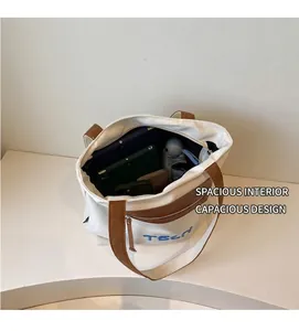 Intérieur spacieux du sac en toile montrant plusieurs tablettes et objets du quotidien
