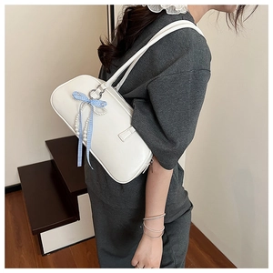 Borsa a spalla bianca con fiocco a quadretti e perle indossata da modella in scala
