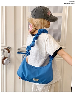 Blaue Hobo-Bag aus Nylon mit Falten-Schultergurt am Model zur Größen- und Stilansicht