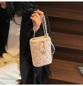 Détails du sac seau rose matelassé avec strass et pendentif en forme d'étoile dorée