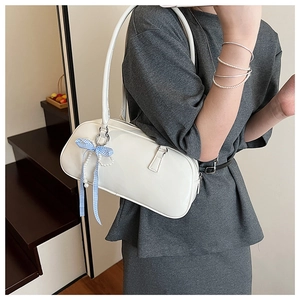 Dettaglio della borsa a spalla in pelle verniciata bianca con fiocco a scacchi e perla