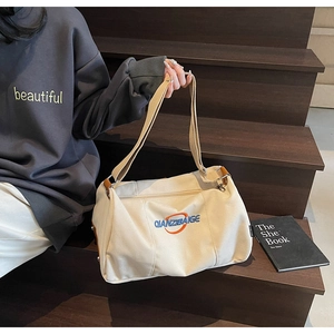 Détail du sac cabas en toile crème avec broderie bleue et fermeture éclair latérale