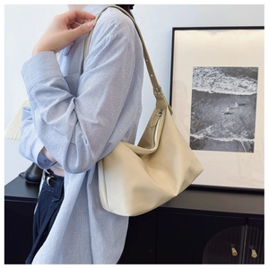 Detail of the adjustable shoulder strap with metal buckle on the beige hobo bag