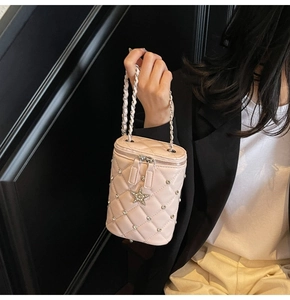 Gros plan du sac seau rose matelassé avec breloque étoile en perles et chaîne argent