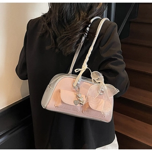 Detailed close-up of pink and silver saddle bag with white lace bow and heart charms