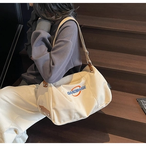 Vue détaillée du sac fourre-tout en toile beige avec logo orange et détails en cuir