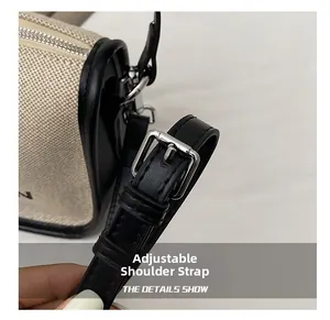 Detail showing adjustable black leather shoulder strap and silver metal buckle on canvas bag