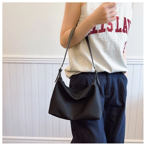 Detail view of black nylon crescent shoulder bag with silver hardware and adjustable strap