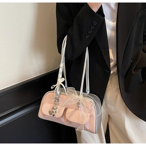 Detail of pink and silver saddle bag with bow ribbon and heart charm on a model