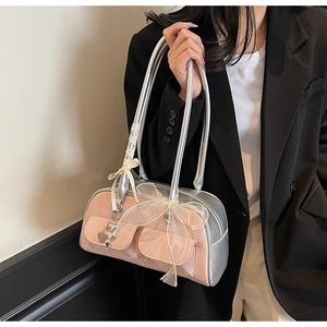 Close-up of pink saddle bag featuring oversized mesh bows and heart charm detail
