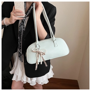 Dettaglio borsa Boston verde menta con ciondolo a fiocco di perle e foulard di seta