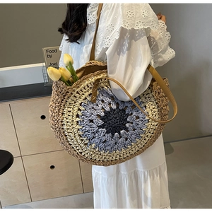 Detailed side view of bohemian straw tote bag with floral pattern and leather straps