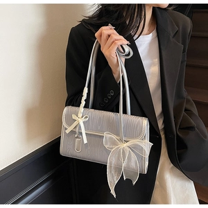 Silver handbag featuring white lace bow details and textured faux leather over shoulder