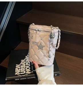Détail du sac seau rose matelassé avec breloques étoiles en perles et bandoulière