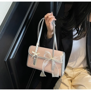 Detailed view of pink shoulder bag featuring white chiffon bows and silver edge trim