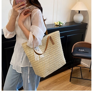 Straw tote bag with white lace trim and brown leather handles in a home setting