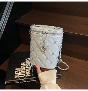 Détail du sac seau matelassé bleu clair avec coutures en losange et strass en étoile