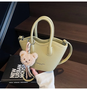 Détail du sac seau vert clair texture litchi avec breloque ours et anneau argenté