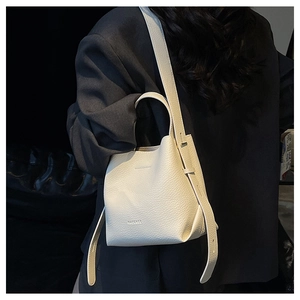 Close-up of cream white lychee pattern bucket bag showing texture and logo